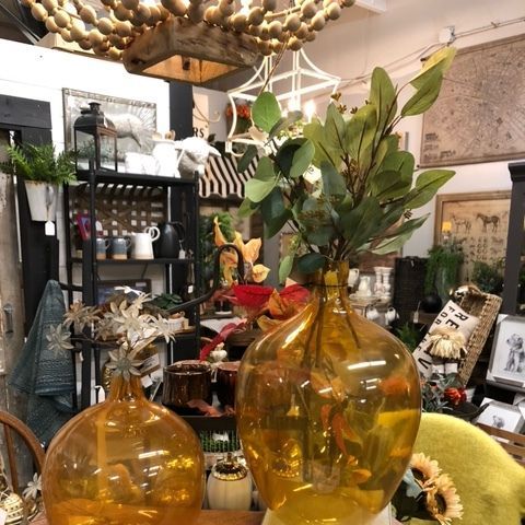 Amber glass vases with greenery in a cozy home decor shop