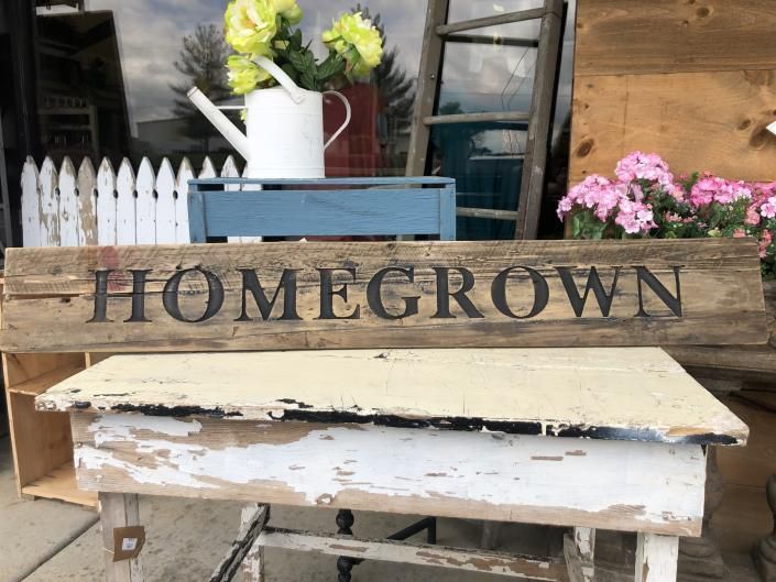 Rustic HOMEGROWN sign with white flowers in a vase on a blue crate and pink flowers nearby