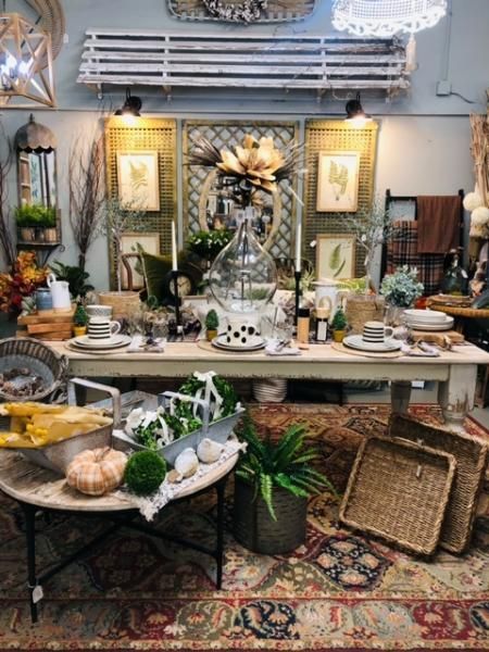Decorated dining room with a long table set with dishes, greenery, and woven baskets in a rustic display