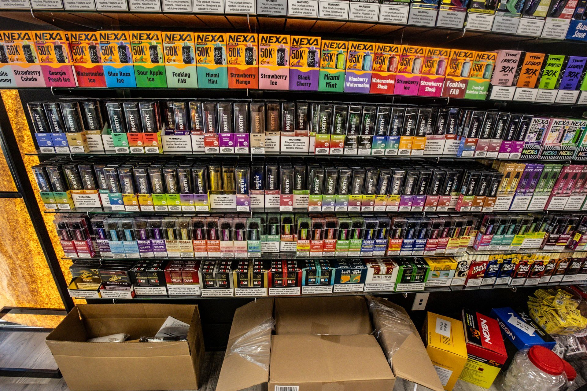 Organized shelf of e-liquid and disposable vape flavors
