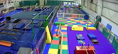 Indoor trampoline park with colorful foam blocks, trampolines, and obstacle course lanes