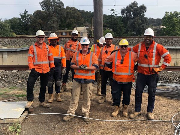 A group of construction workers are posing for a picture.
