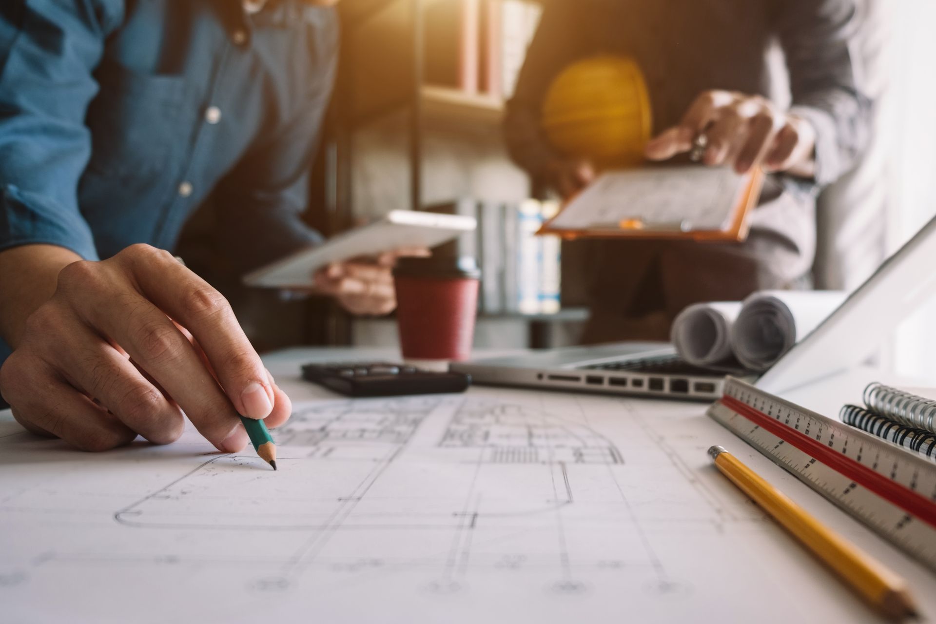 A man is drawing on a piece of paper with a pencil.