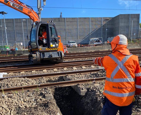A construction worker wearing an orange vest with the word railway on the back