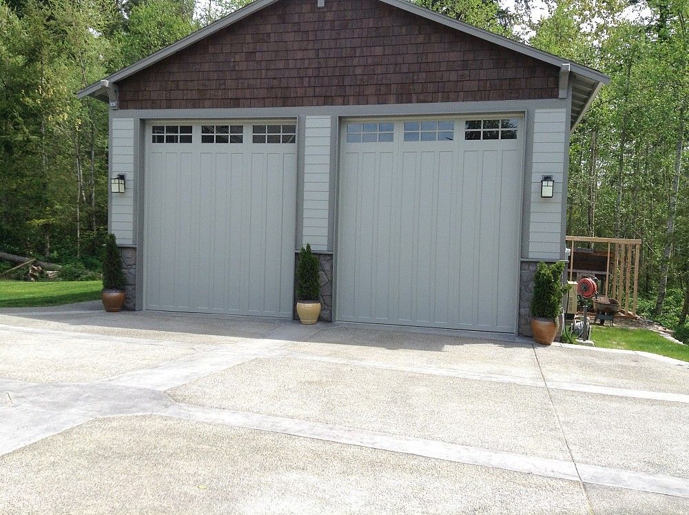 A garage with two white doors and a brown roof