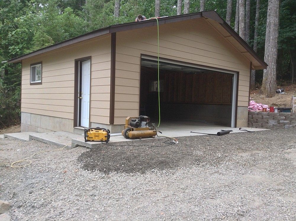 A garage with a yellow air compressor in front of it