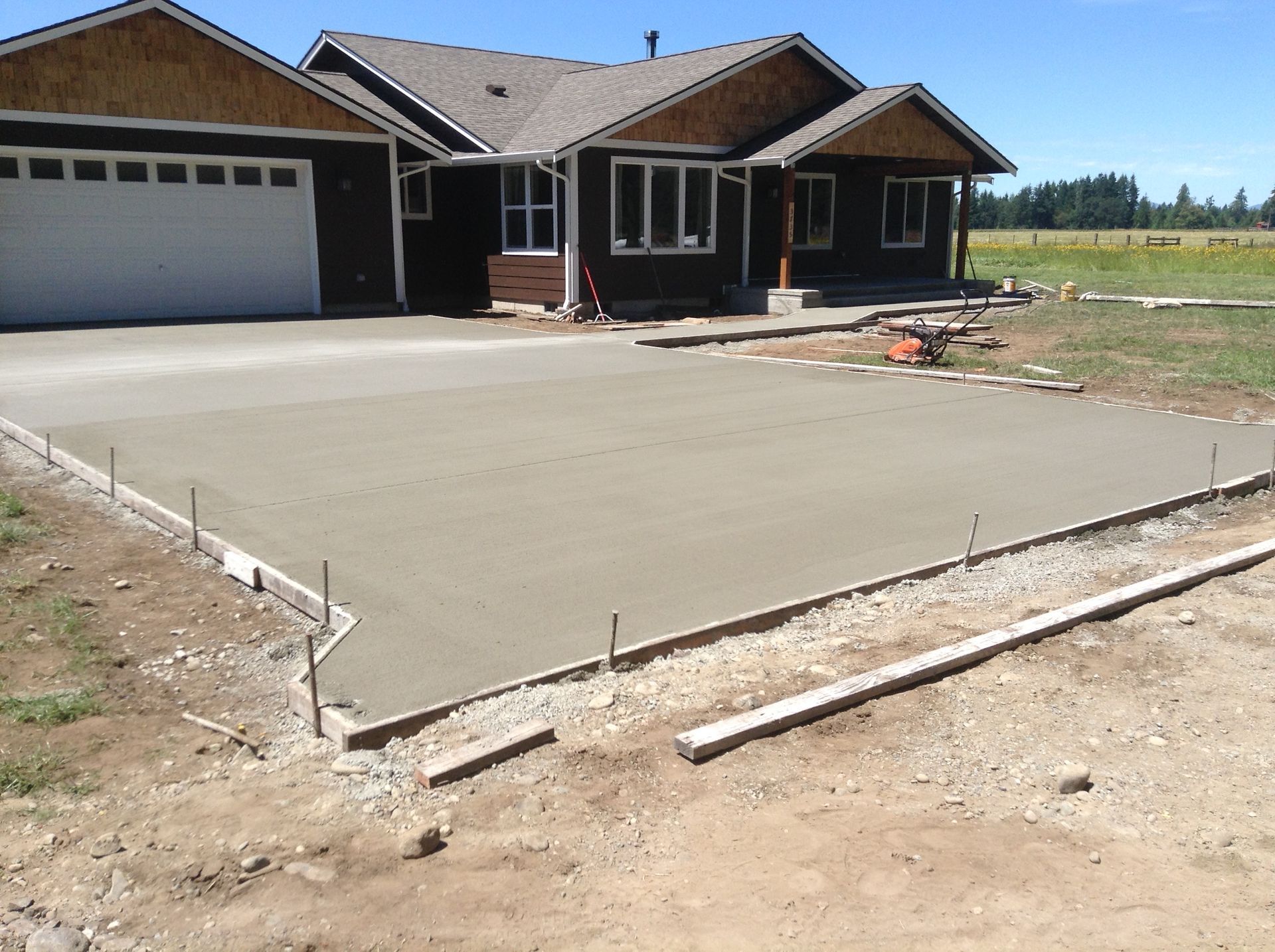A concrete driveway is being built in front of a house
