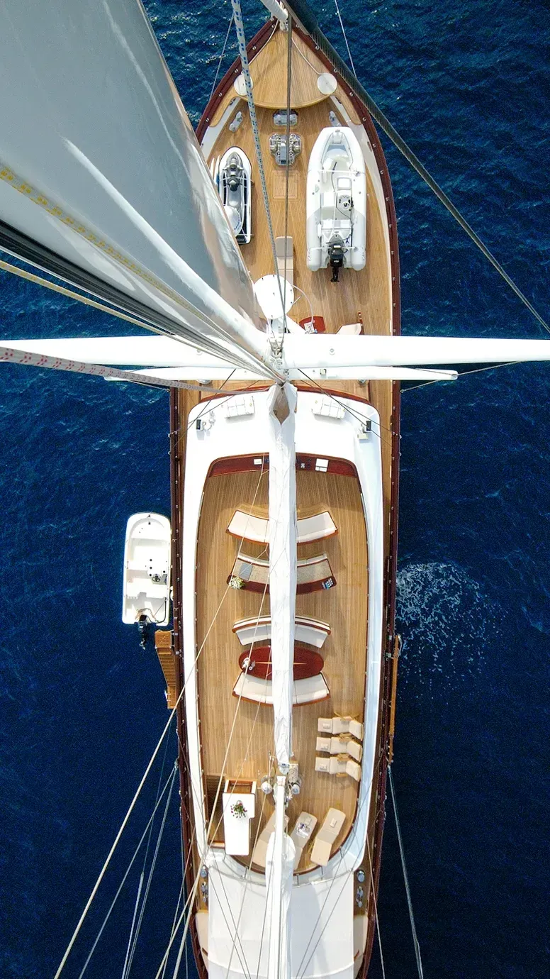 Sailboat with white sails gliding across deep blue water