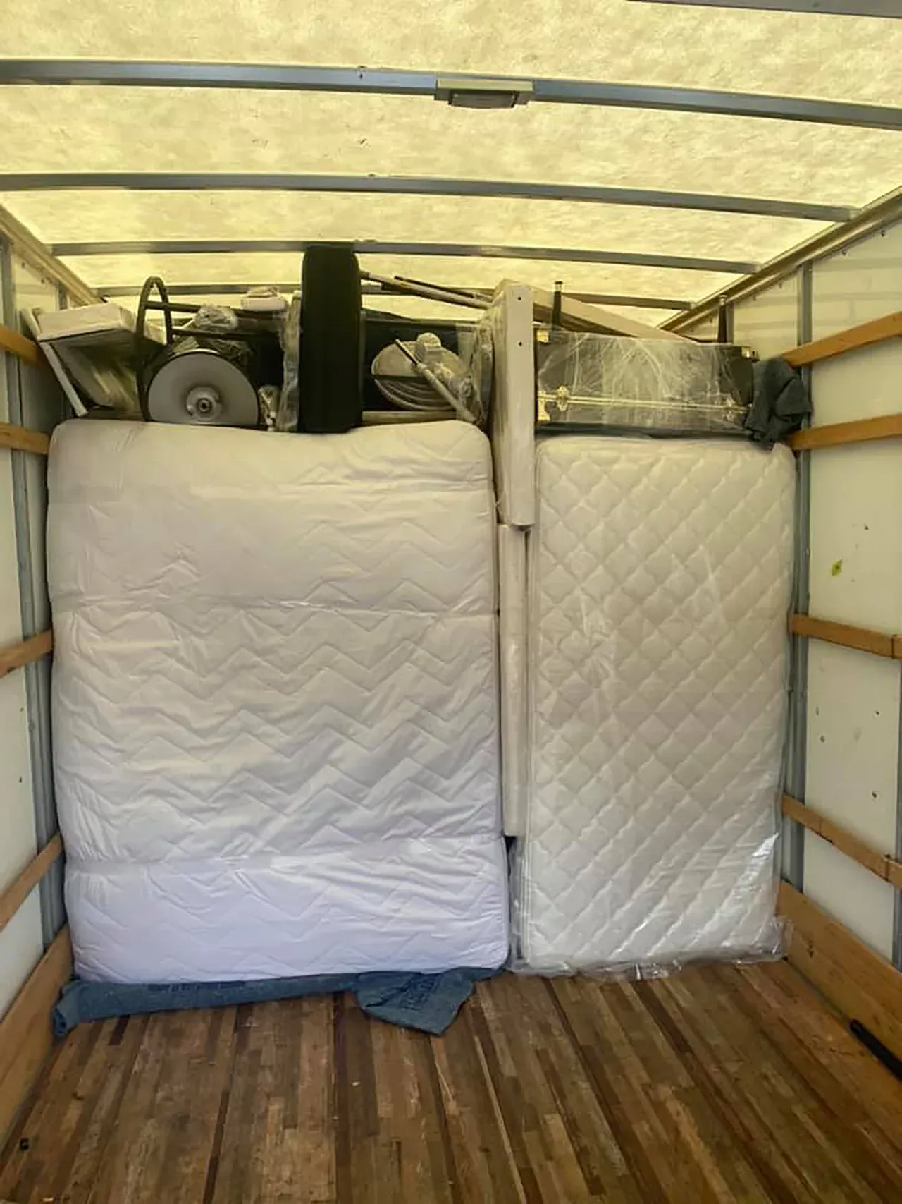 A truck filled with mattresses and other furniture.