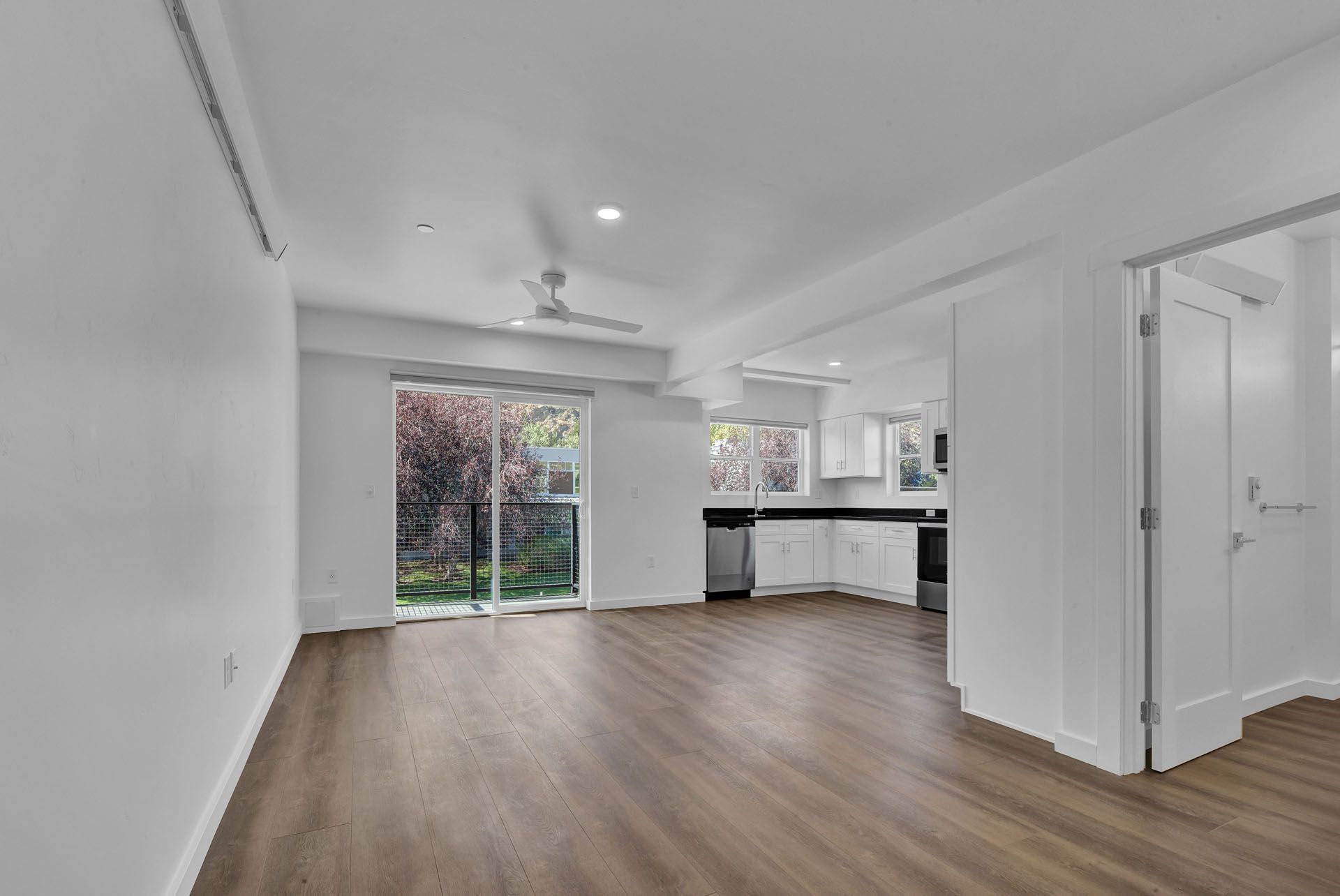 An living room with hardwood floors and a ceiling fan.