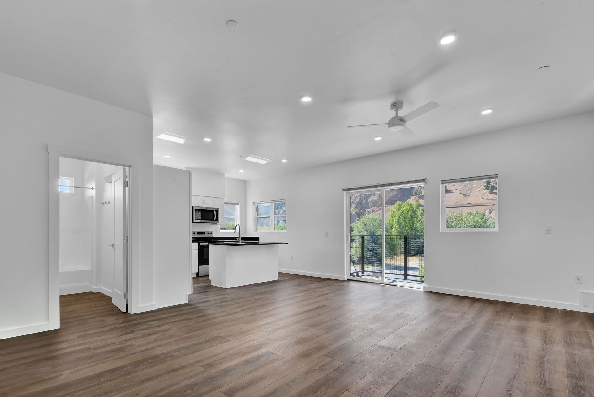 An living room with hardwood floors and a ceiling fan.