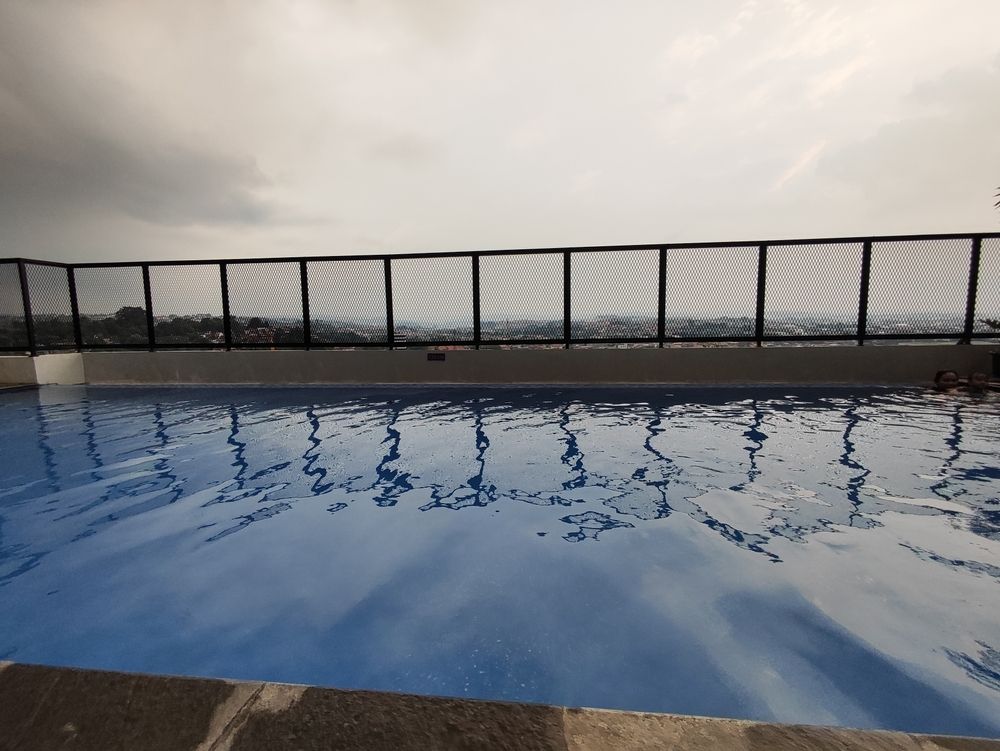 Empty Rooftop Pool Under a Cloudy Sky, With a Black Fence — Everyday Maintenance Pty Ltd In Beaconsfield, QLD