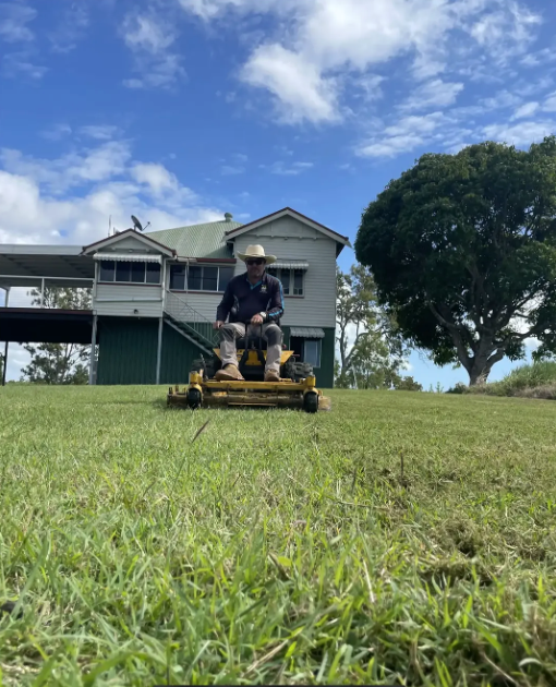 Person on a Yellow Riding Mower Cutting Grass — Everyday Maintenance Pty Ltd In Beaconsfield, QLD