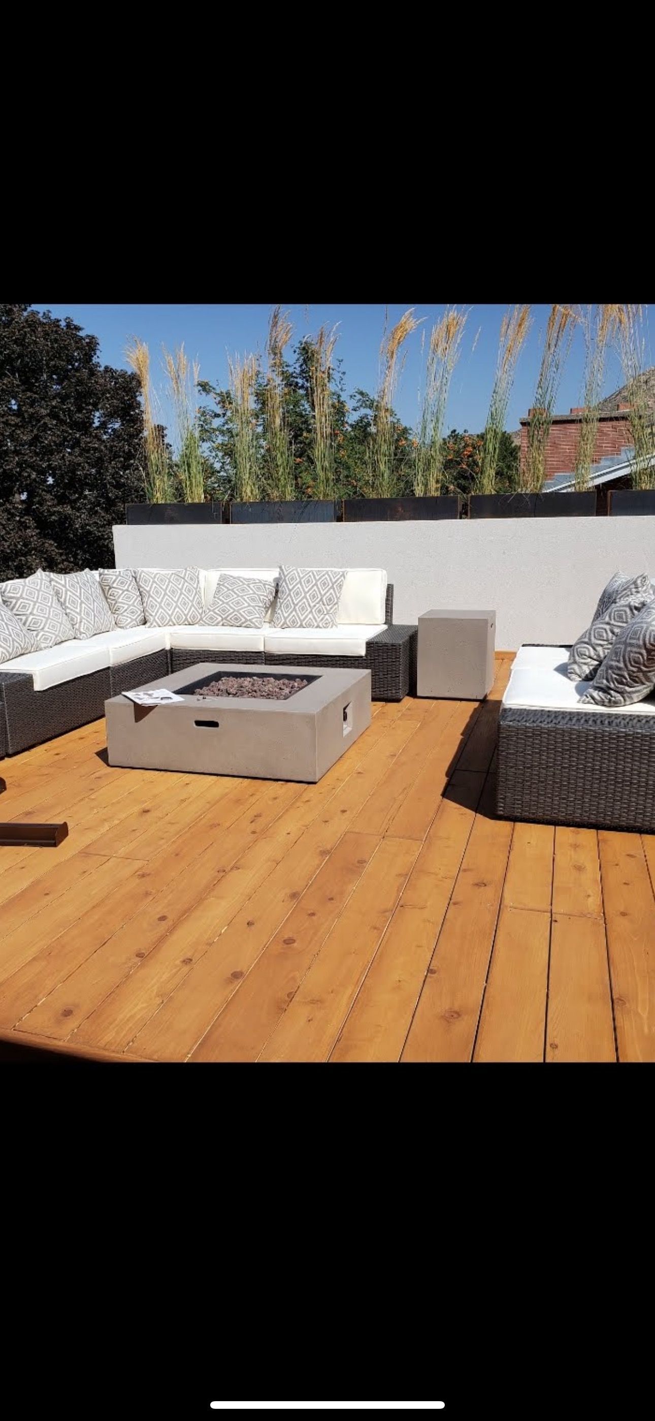 A wooden deck with a fire pit and a couch.