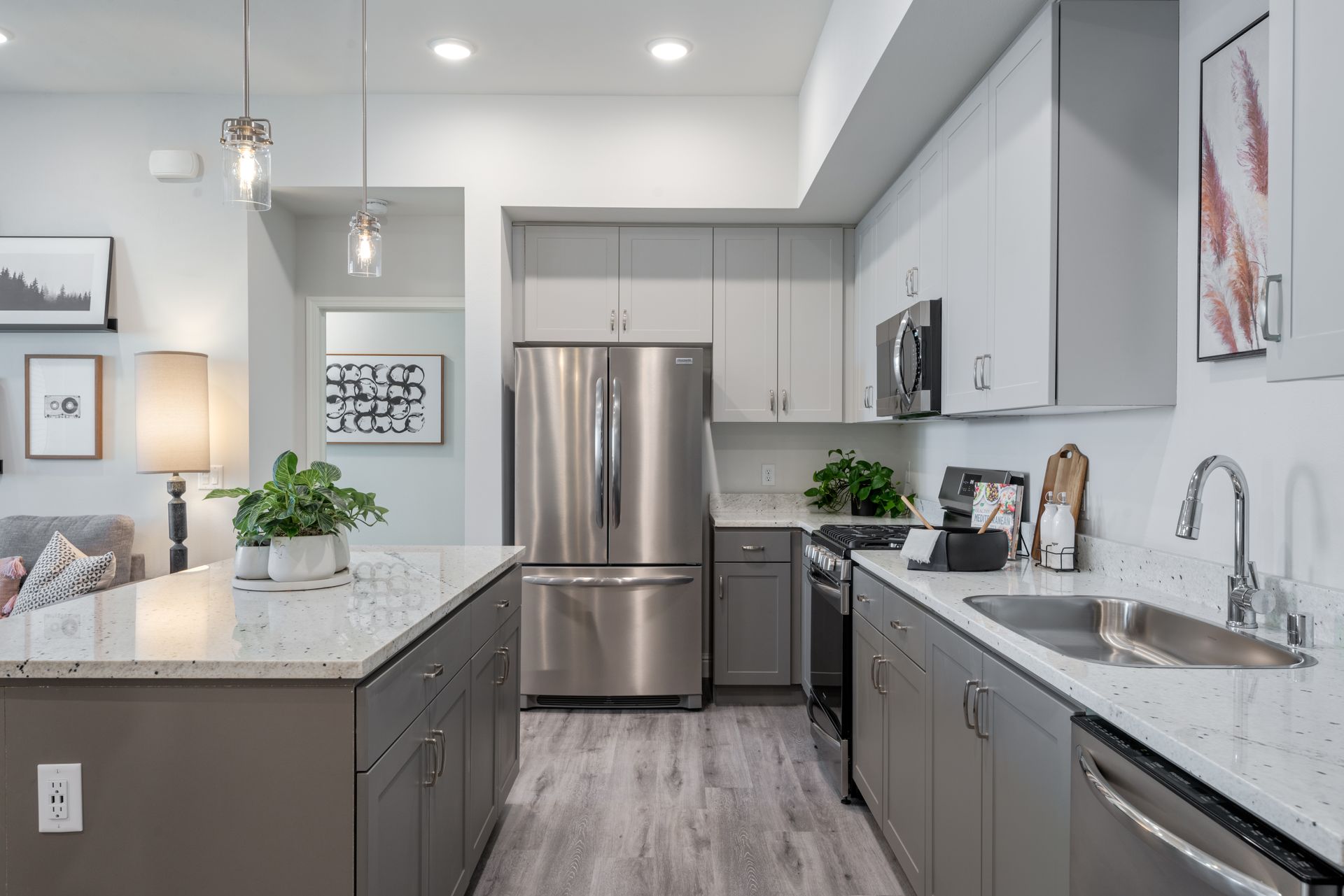 Modern kitchen with gray cabinets, stainless steel appliances, and an island.