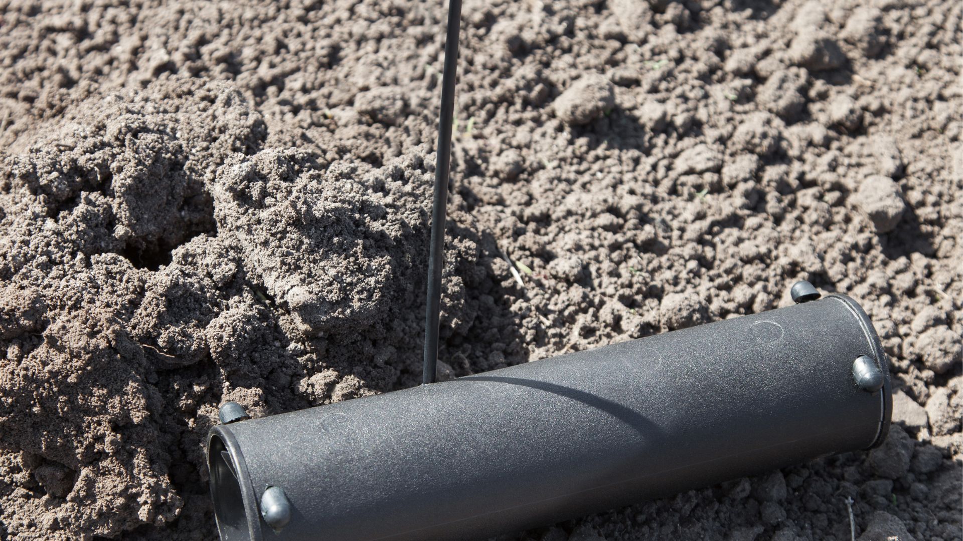 A black object is sitting on top of a pile of dirt.