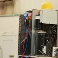 Open electrical panel with gauges, wiring, and red and blue hoses in a workshop
