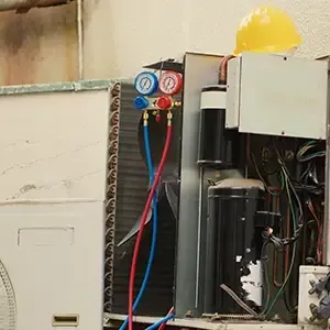 Open electrical panel with gauges, wiring, and red and blue hoses in a workshop