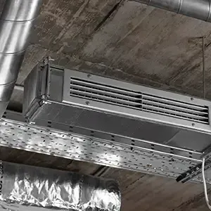 Industrial ceiling-mounted metal air duct in a concrete ceiling space