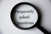 Magnifying glass over the words “Frequently asked Questions” on a white background