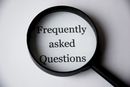 Magnifying glass over the words “Frequently asked Questions” on a white background