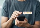 Person typing on a smartphone with a 5-star rating icon floating above it.