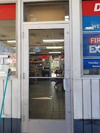 A store front with a glass door and a mop in front of it.