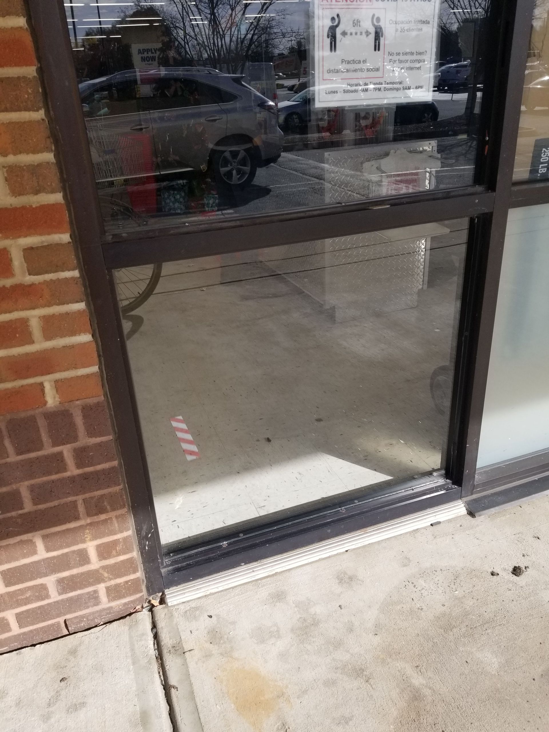 A car is reflected in a window of a building.