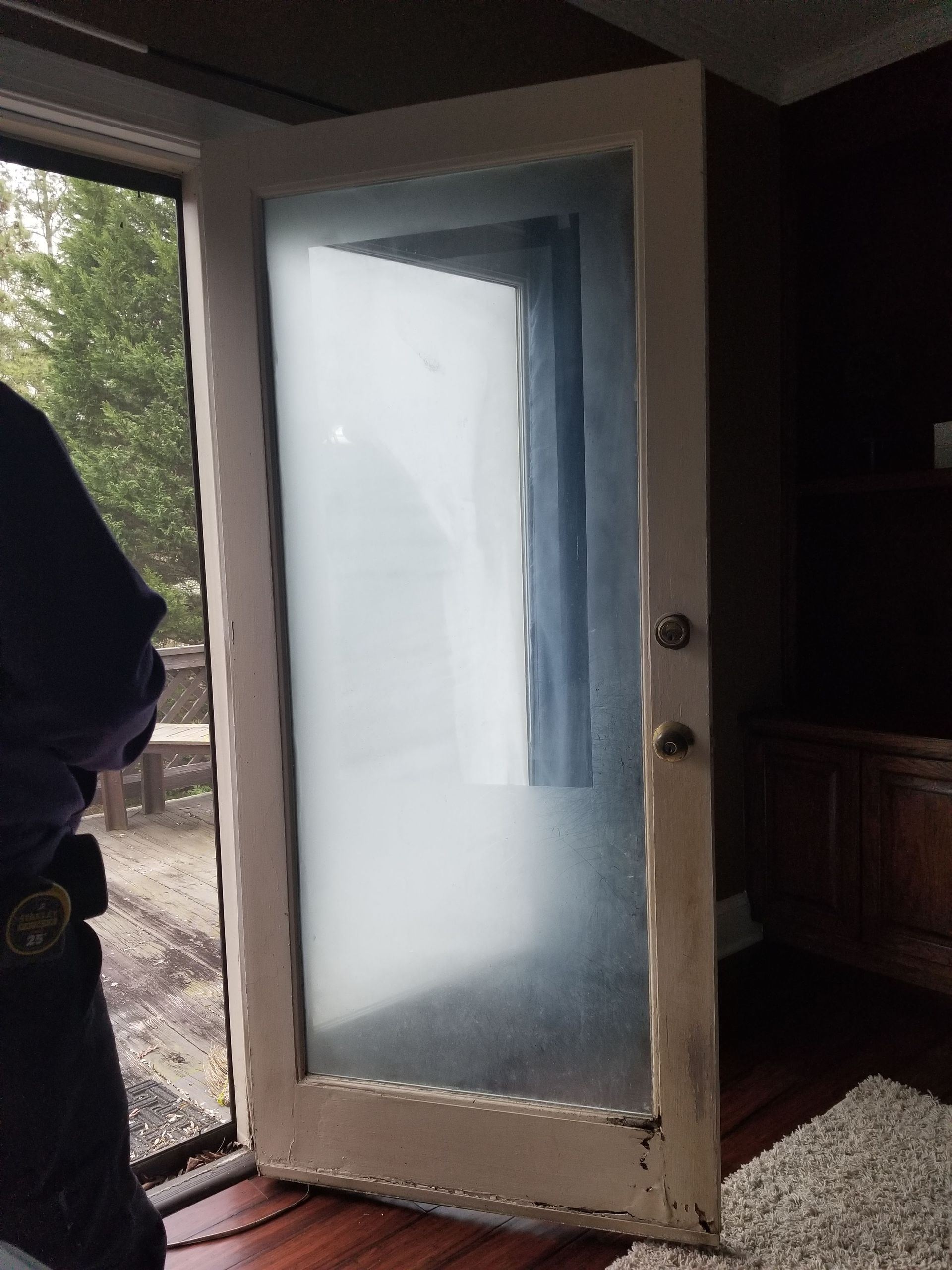 A person is standing in front of a door that is open