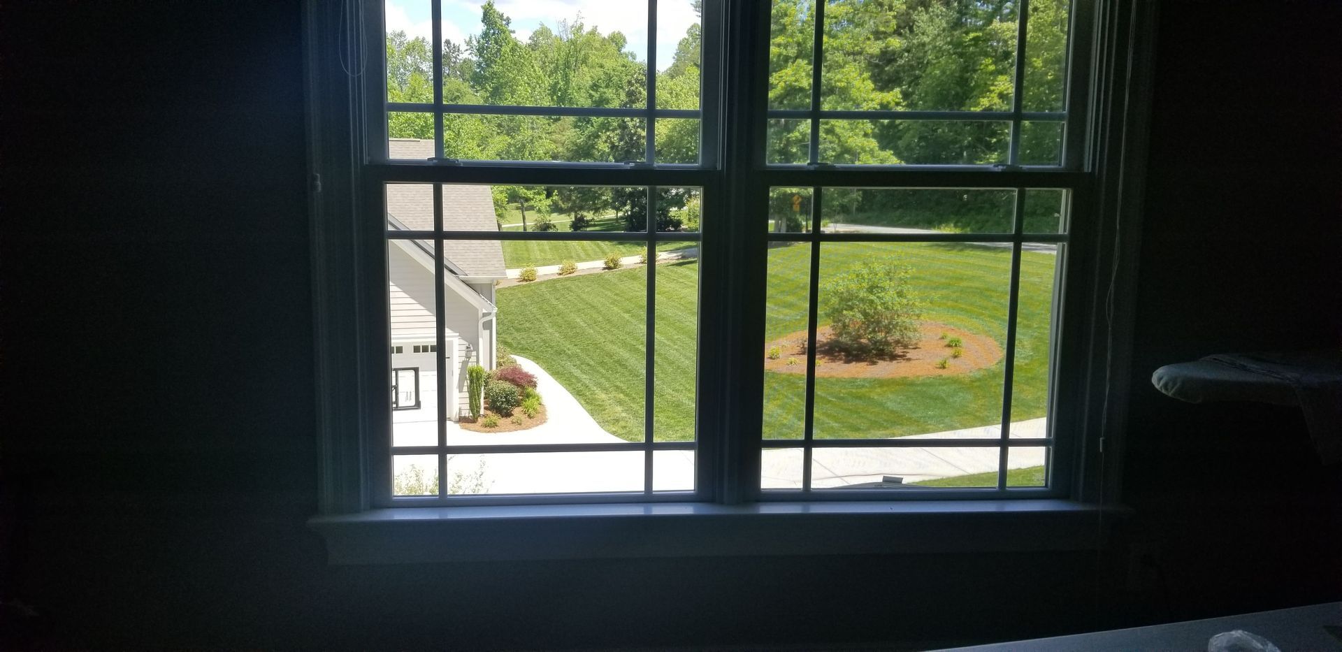 A window with a view of a yard and a house.