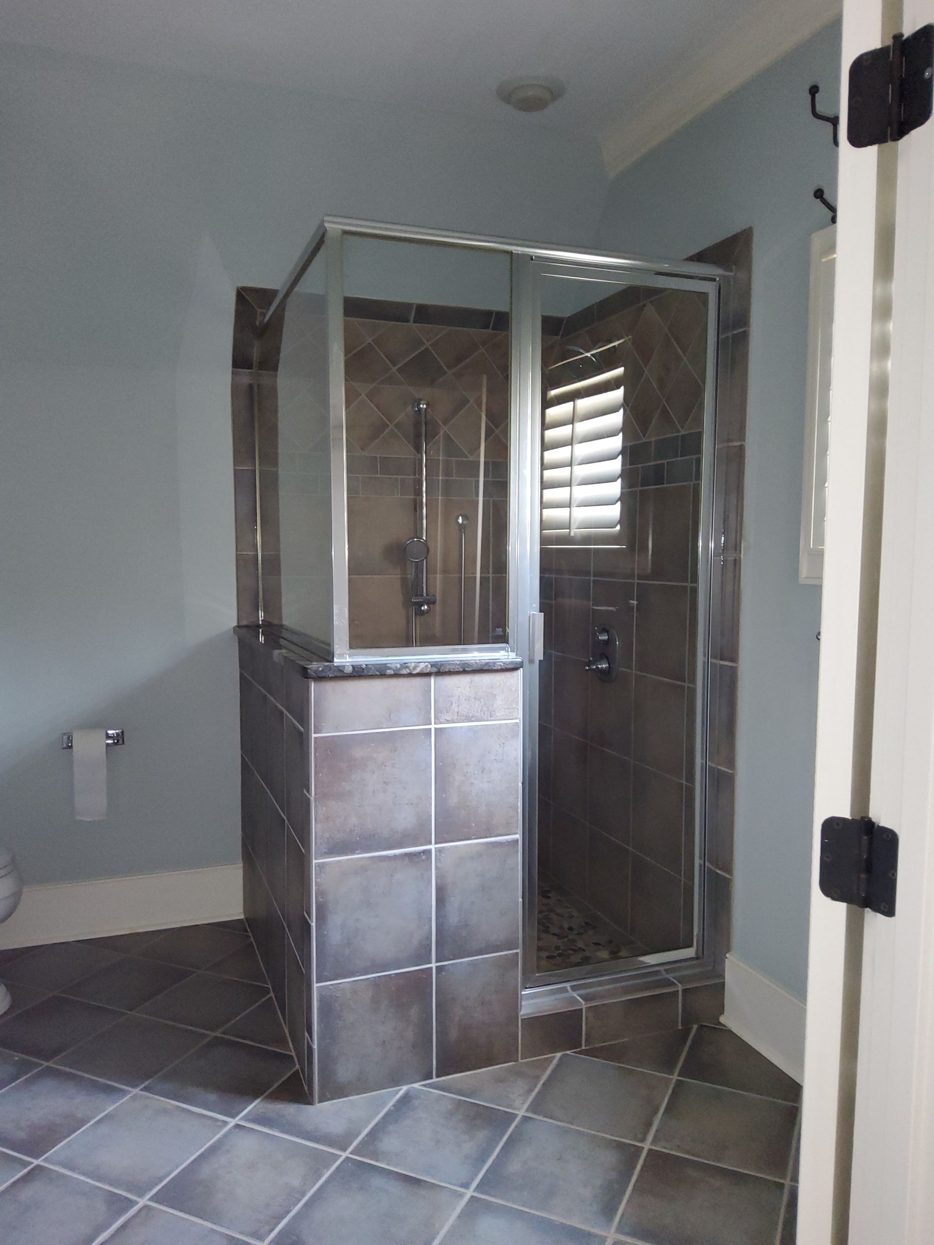 A bathroom with a walk in shower and a window