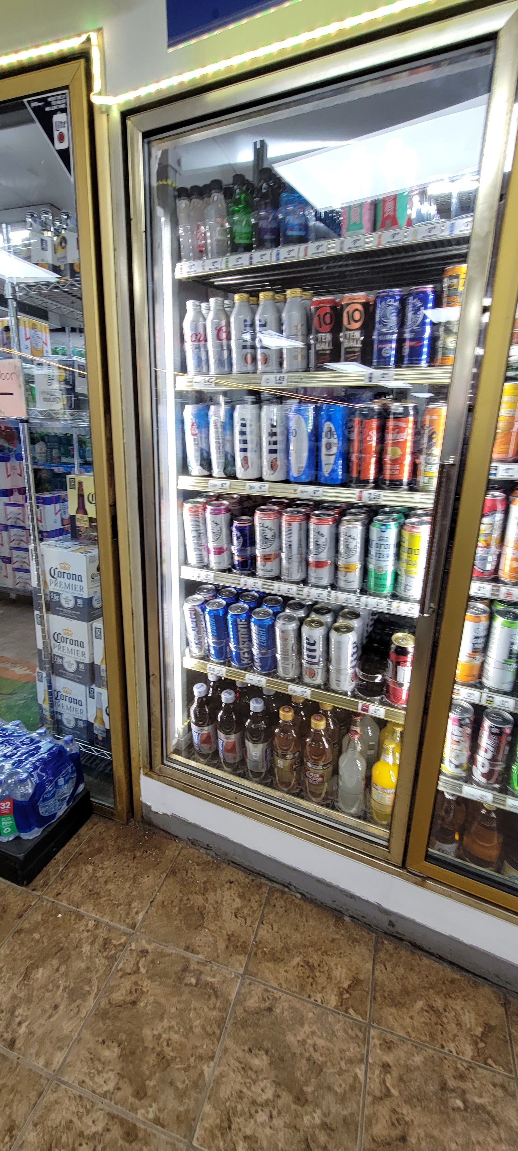 A refrigerator filled with lots of cans and bottles in a store.