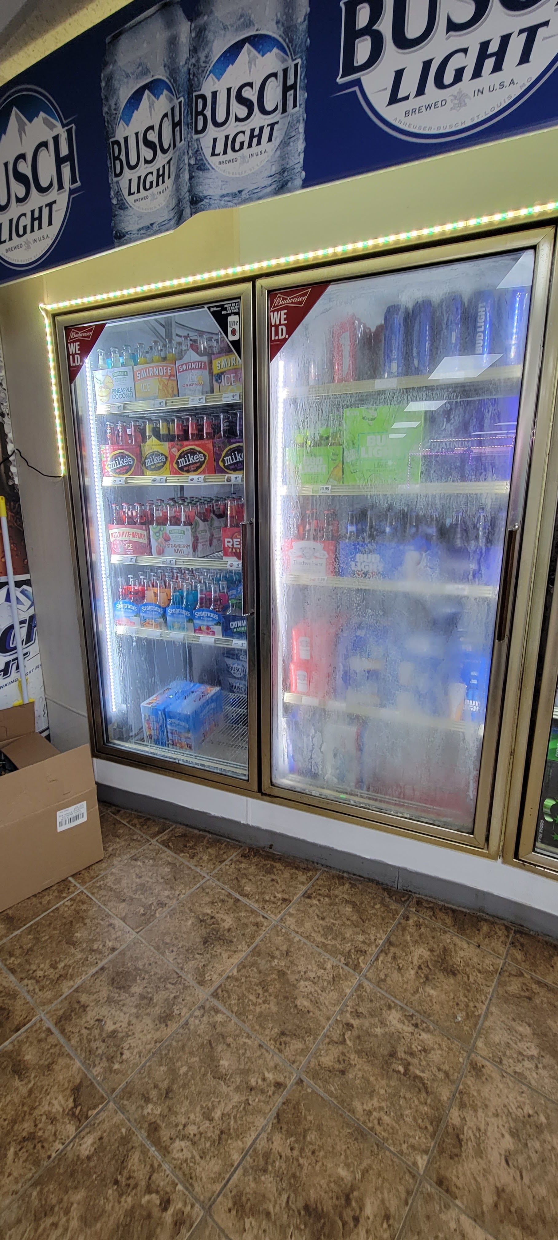 A cooler filled with beer and soda in a store.