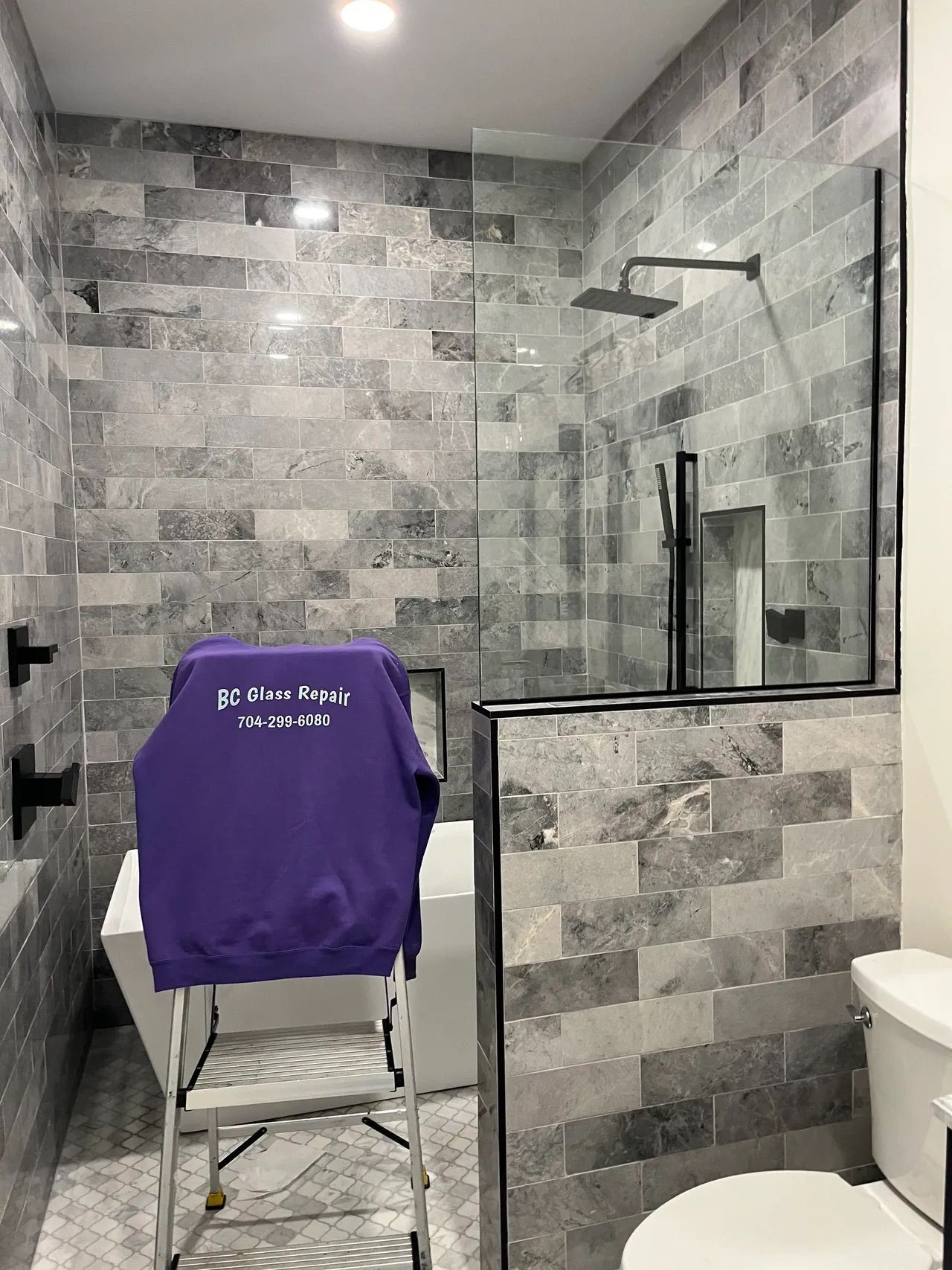 A bathroom with a walk in shower and a toilet.
