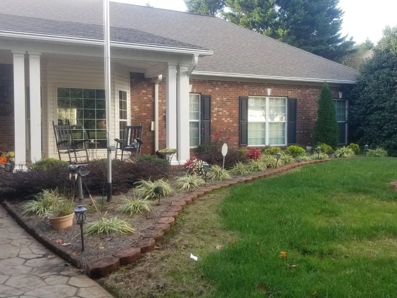 A brick house with a large lawn in front of it
