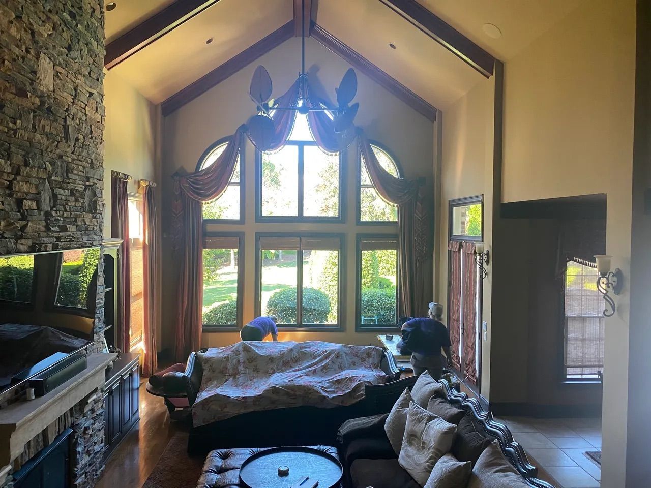 A living room with a couch , fireplace , and lots of windows.