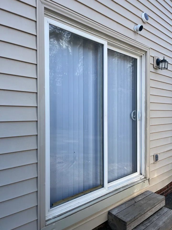 A sliding glass door is on the side of a house.