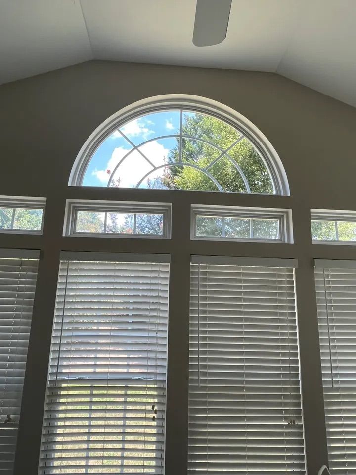 A large window with blinds and a ceiling fan