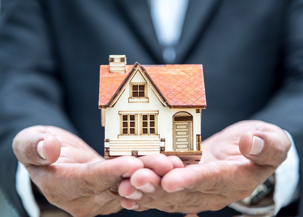 Person Holding A Home Model — Chicago, IL — Metropolitan Insurance Service Consultants, Inc Person Holding A Home Model — Chicago, IL — Metropolitan Insurance Service Consultants, Inc