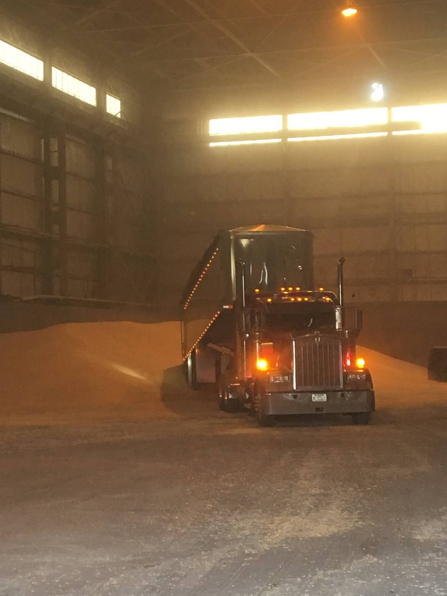 Dump trailer from GFI Transport , facing camera with headlights on.