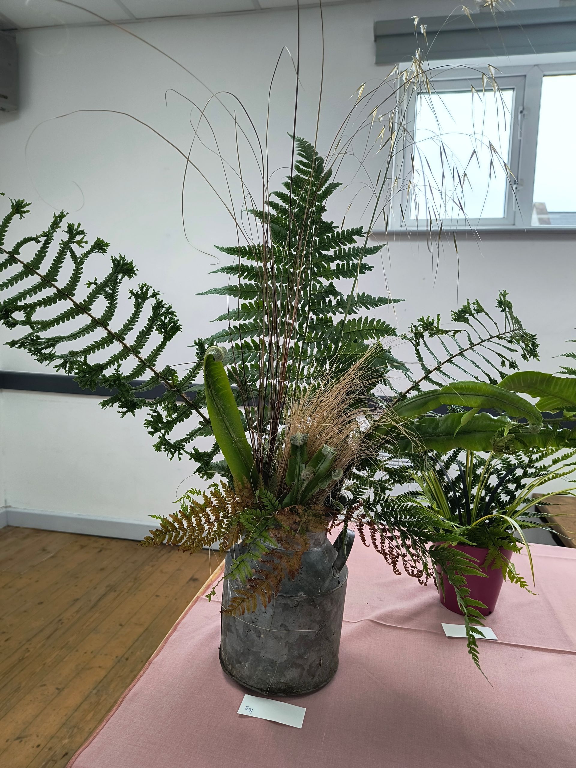 An arrangement of ferns and glasses in a tall glass