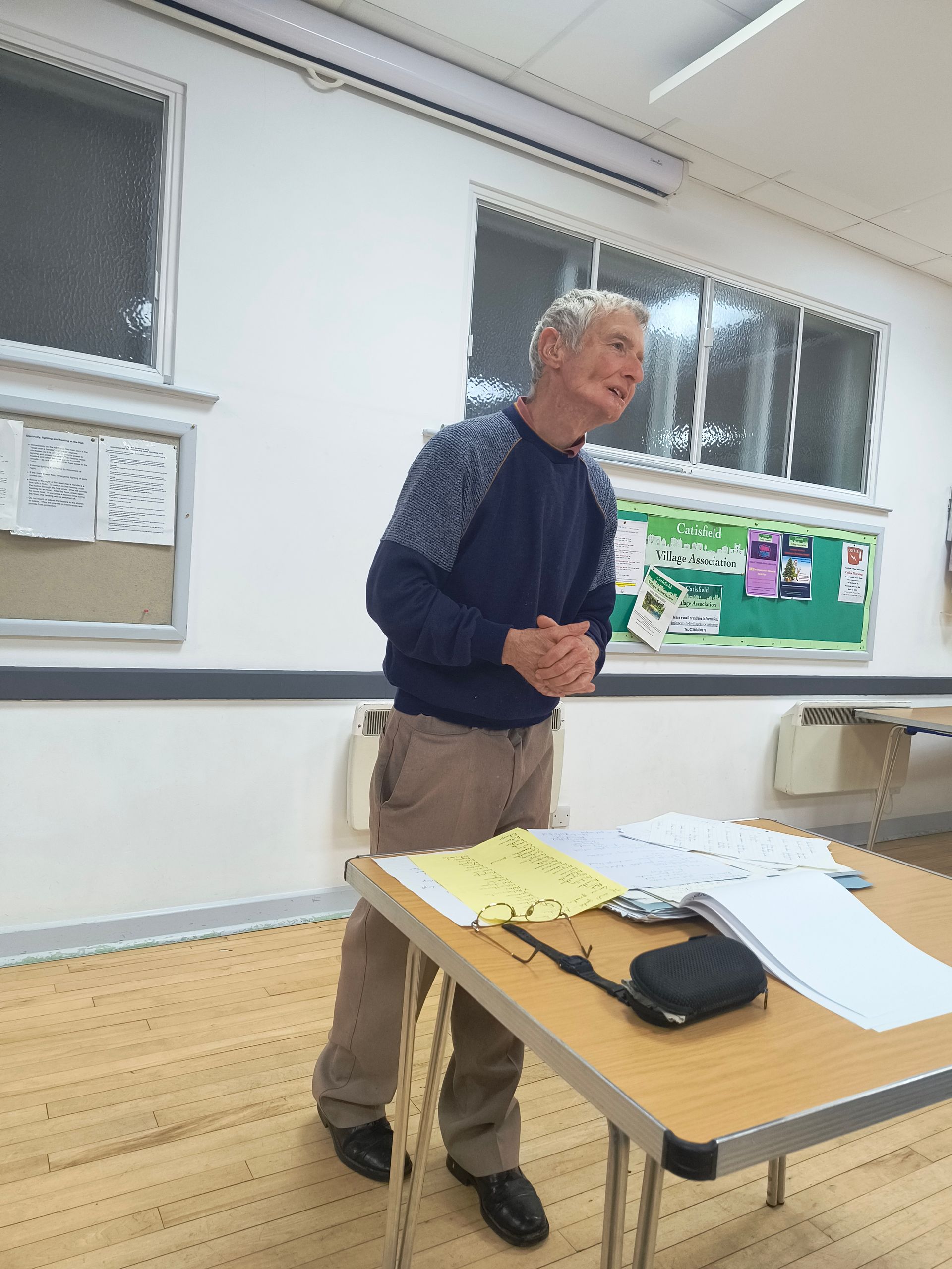 Photo shows Kelvin Mason at front of hall replying to questions from Club members