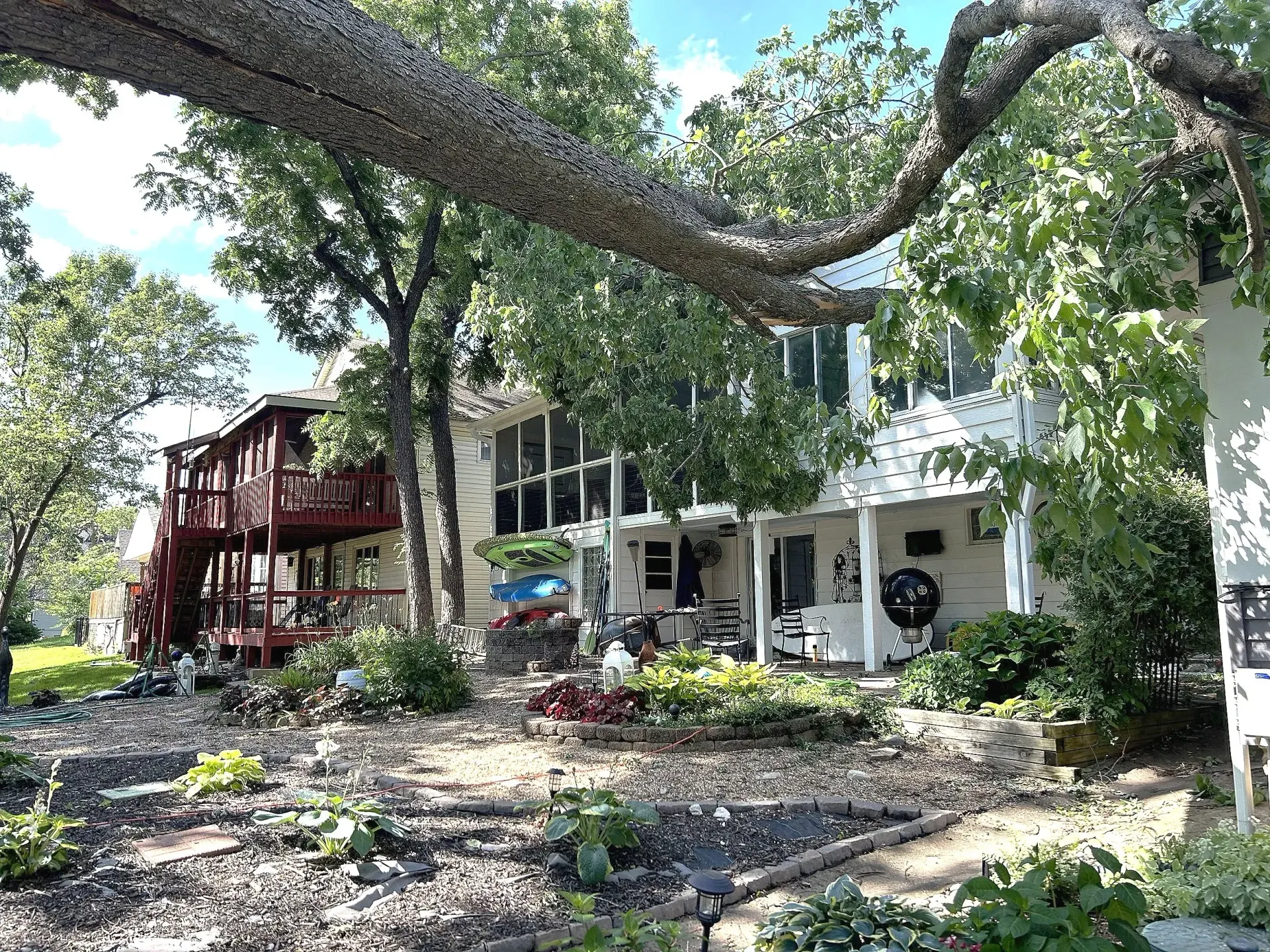 A white house with a red balcony, surrounded by trees and a garden on a sunny day. A white house with a red balcony, surrounded by trees and a garden on a sunny day.