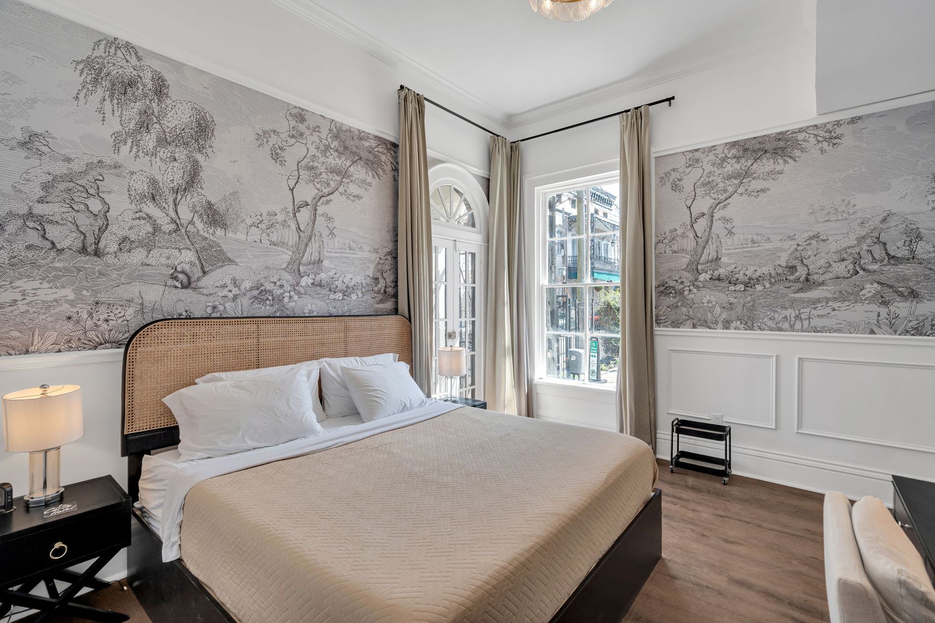 Elegant bedroom with floral wallpaper, white bedding, and a window with daylight.