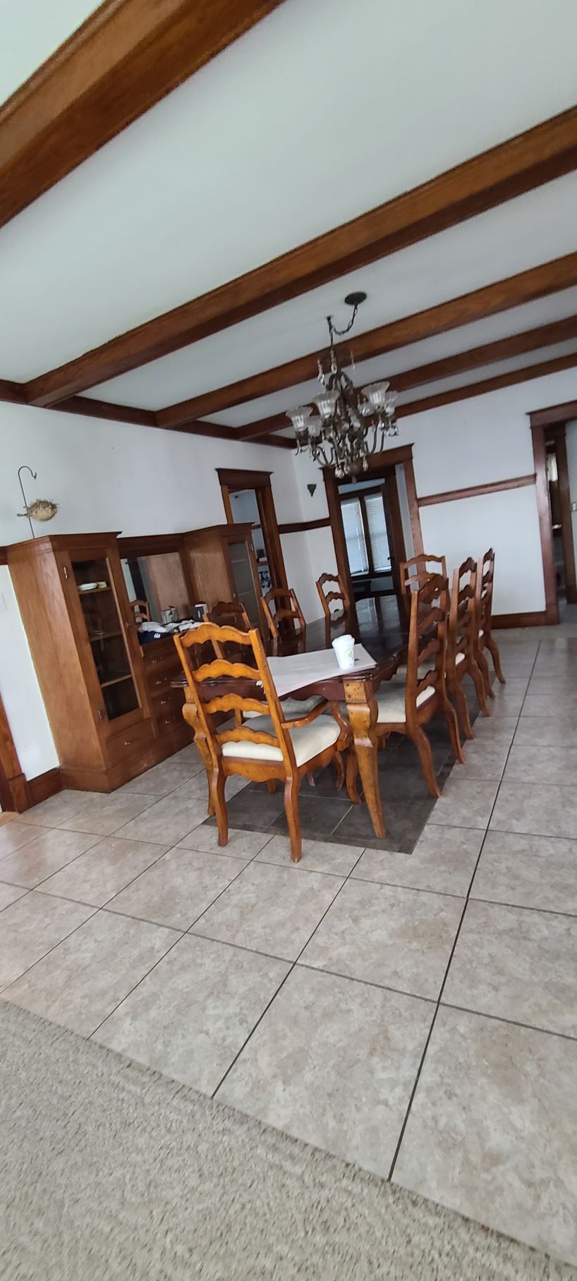 A large dining room with a table and chairs and a chandelier.