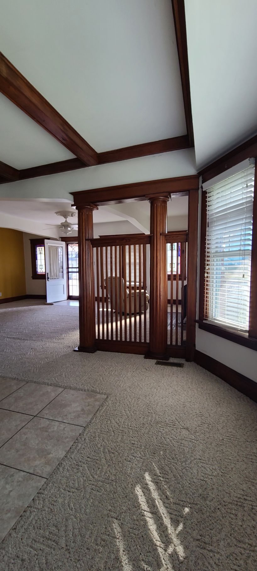 A large empty room with a wooden door and a lot of windows.