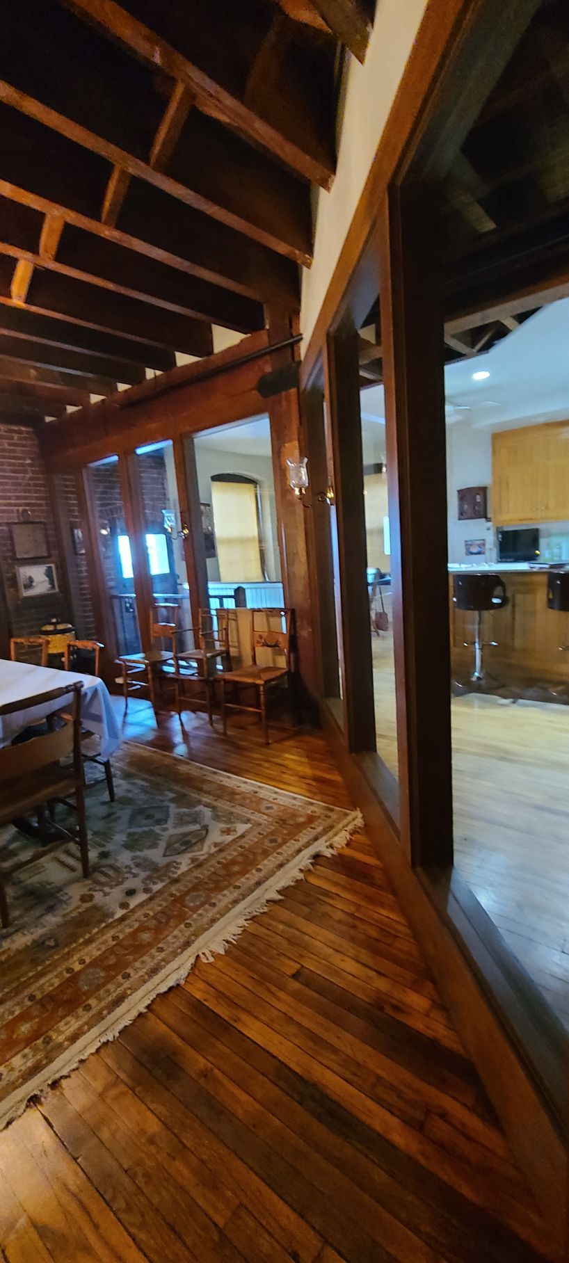 A living room with hardwood floors and a table and chairs.