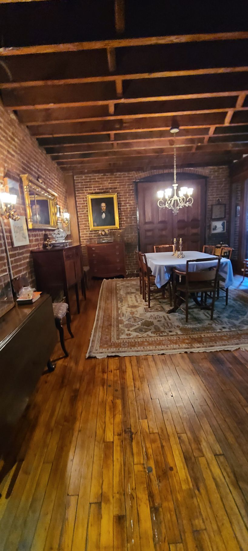 A large dining room with a table and chairs and a chandelier.