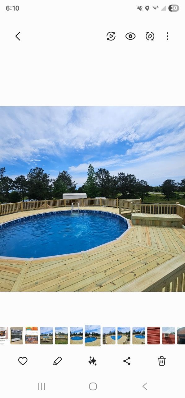 Backyard deck with an empty blue above-ground pool under a partly cloudy sky