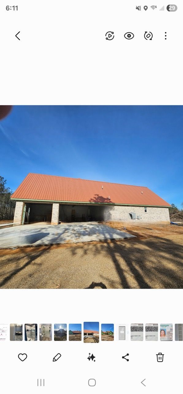 Stone building with red roof under a bright blue sky on a sunny day
